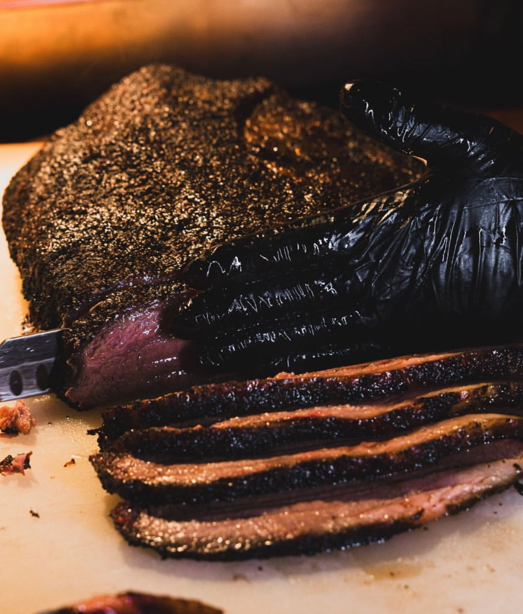 The pitmaster carving a smoked brisket